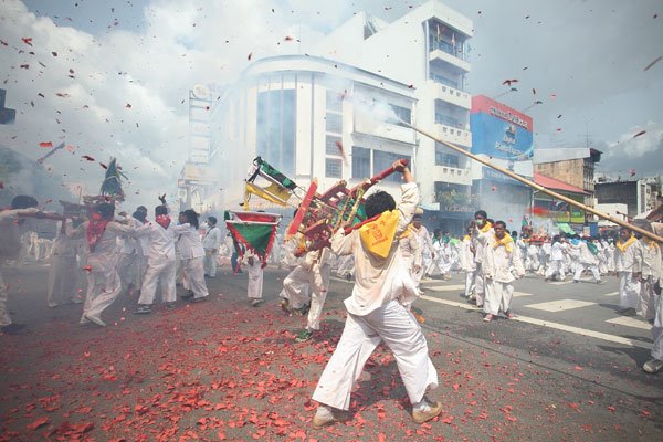 Firecrackers accompany parading icons of the Nine Emperor Gods during the Trang Vegetarian Festival.